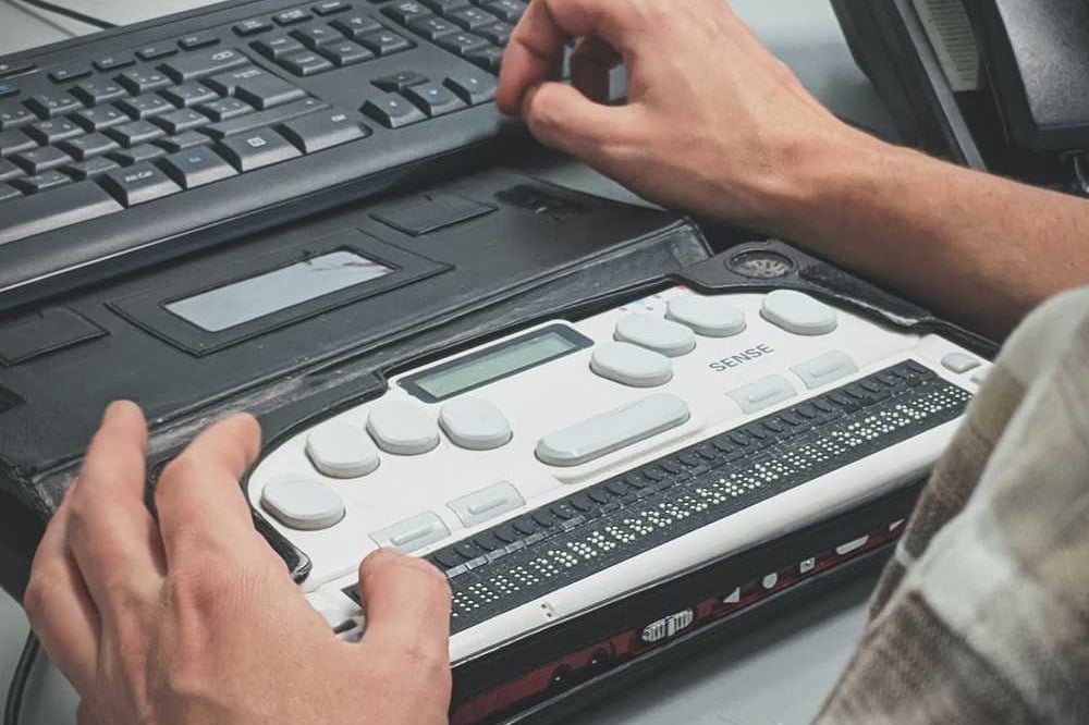 A person using a braille writer